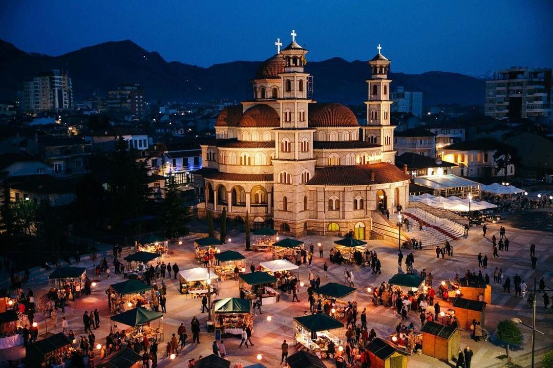 The cathedral square in Korçë at dusk, with an evening market